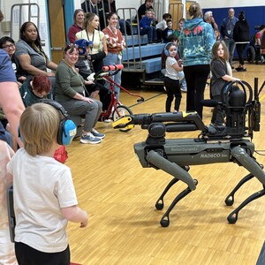 Students and staff interacting with the robotic dogs